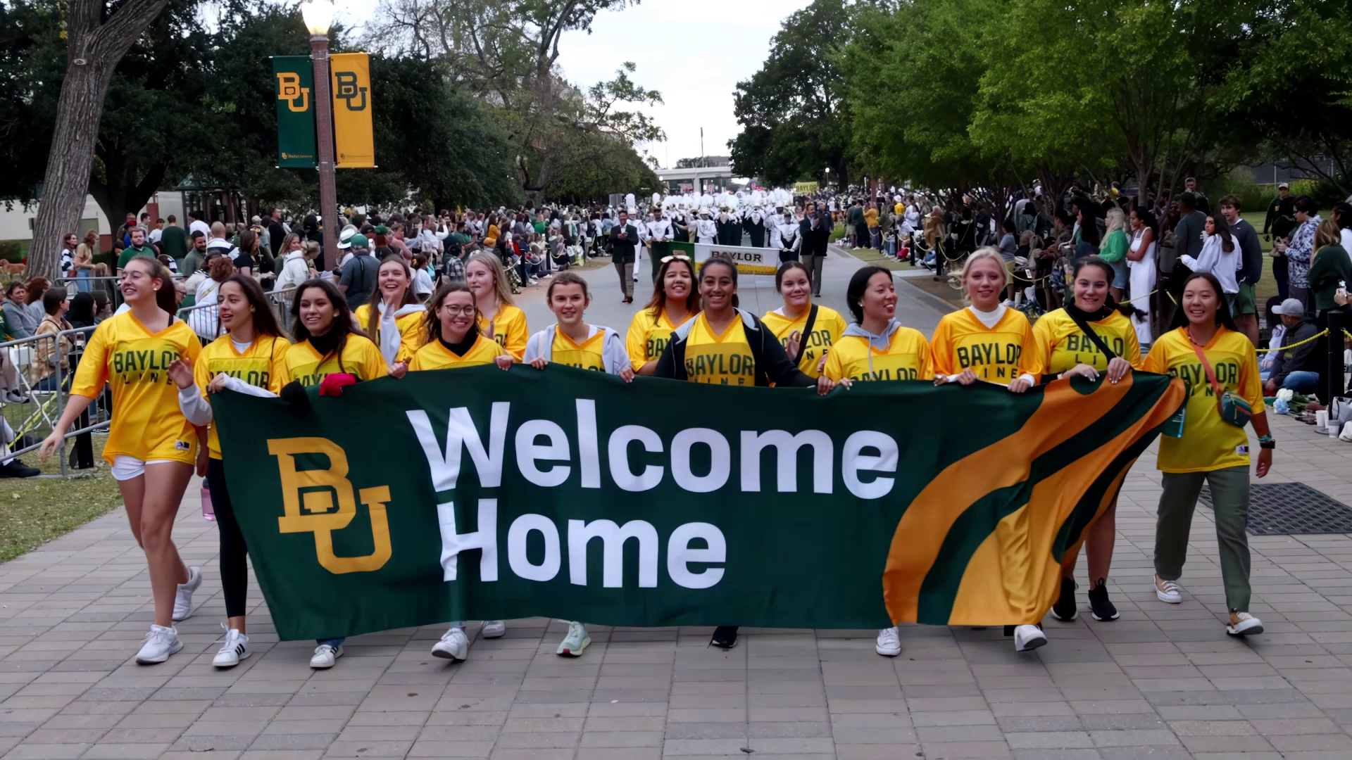 Baylor University Homecoming parade with banner and happy students